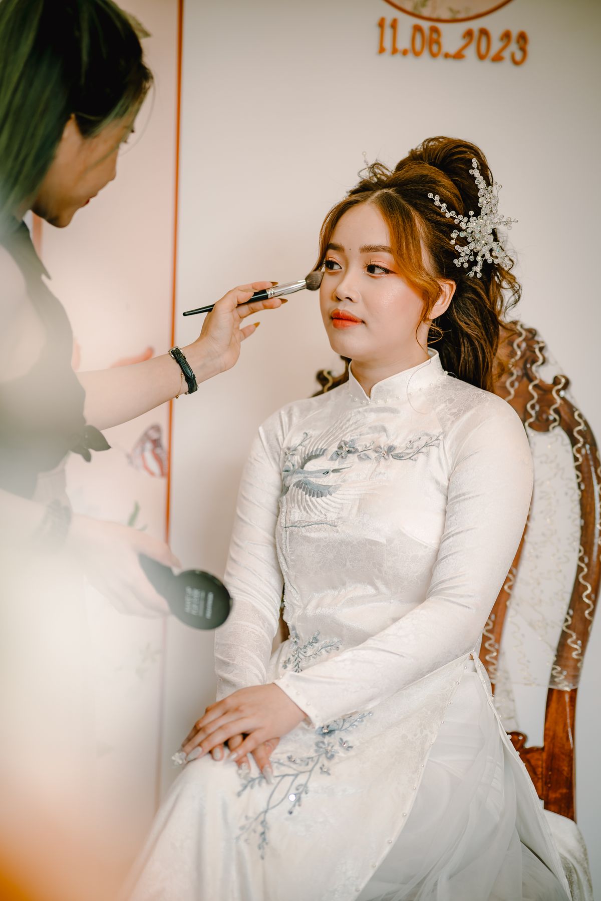 A bride receiving the finishing touches to her makeup