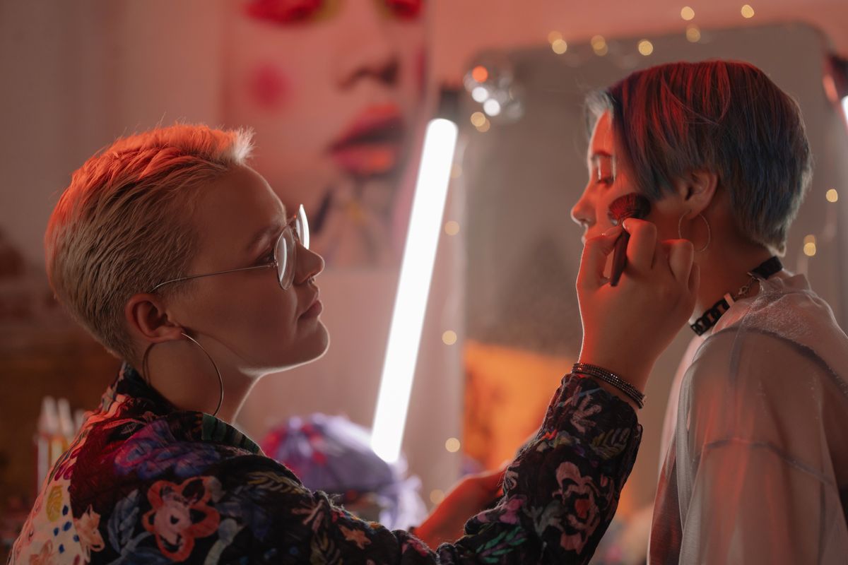 A makeup artist applying blush with a brush