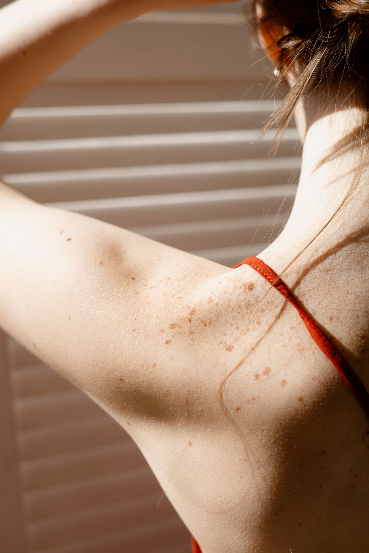 Warm light and soft shadows across a woman's shoulder